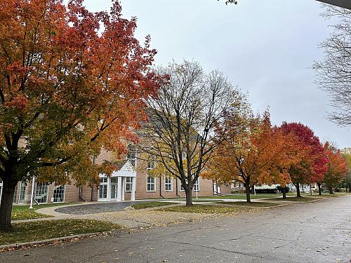 The side entrance of First Congregational Church, with Bushnell St and brightly colored fall leaves in front of it.